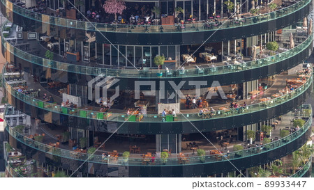 Dubai marina waterfront and building with different restaurants at each floor aerial timelapse. Dubai marina waterfront and building with different restaurants at each floor aerial timelapse. 89933447