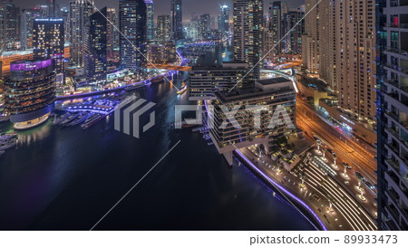 Aerial view to Dubai marina skyscrapers around canal with floating boats night timelapse 89933473