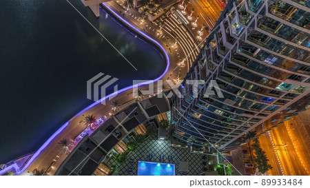 Dubai marina promenade on waterfront along canal aerial night timelapse. Dubai marina promenade on waterfront along canal aerial night timelapse. 89933484