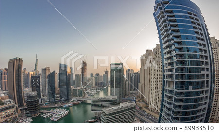 Aerial view to Dubai marina skyscrapers around canal with floating boats day to night timelapse 89933510