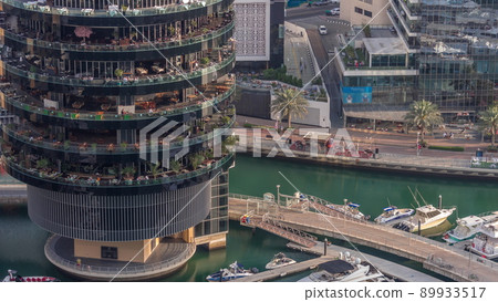 Dubai marina waterfront and building with different restaurants at each floor aerial timelapse. Dubai marina waterfront and building with different restaurants at each floor aerial timelapse. 89933517