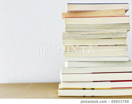 Many books piled up_white wall background 89933798