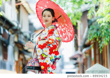 一個穿著和服的年輕女子拿著一把日本雨傘 89934215
