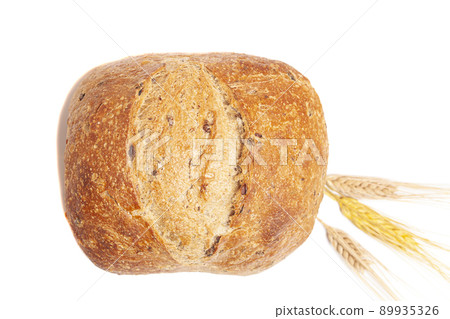 Loaf of round bread with wheat ears isolated on white background. 89935326