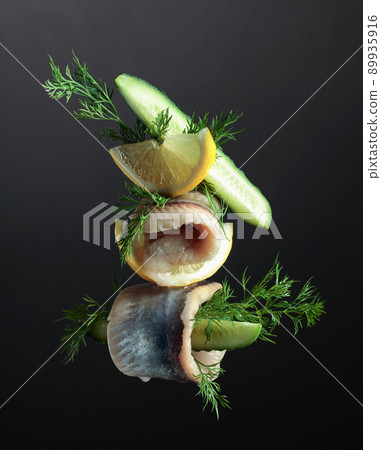 Herring fillet in oil with lemon, cucumber, and dill. 89935916