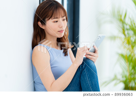 Woman operating a smartphone Woman operating a smartphone 89936063