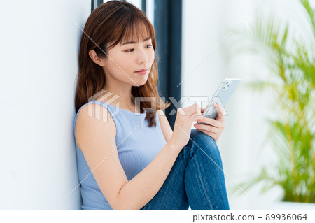 Woman operating a smartphone Woman operating a smartphone 89936064