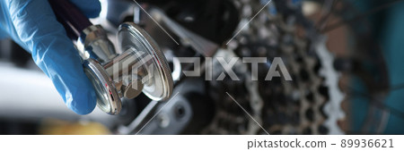 A gloved hand holds a key to adjust the bike 89936621
