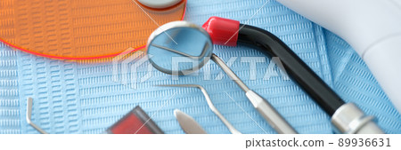 Dental instruments and denture lie on a blue medical napkin Dental instruments and denture lie on a blue medical napkin 89936631