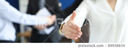 Smiling business woman stretches out her hand in the office Smiling business woman stretches out her hand in the office 89936634