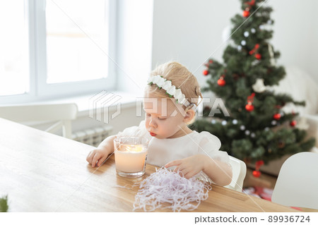 Child girl dressed in christmas dress with cochlear implants having fun at home - diversity and hearing aid and innovating technologies for treatment of deafness. Copy space and place for advertising 89936724