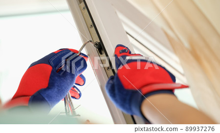 Master in gloves adjusting pvc windows with screwdriver closeup 89937276