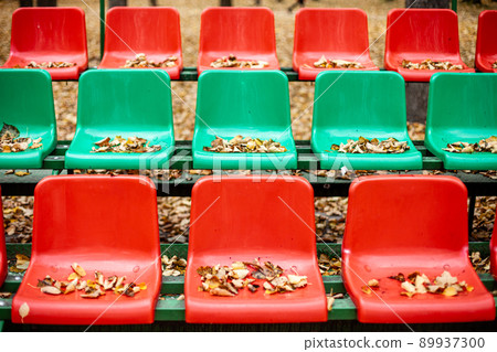 Empty sports stands with red and green seats on an autumn day. 89937300