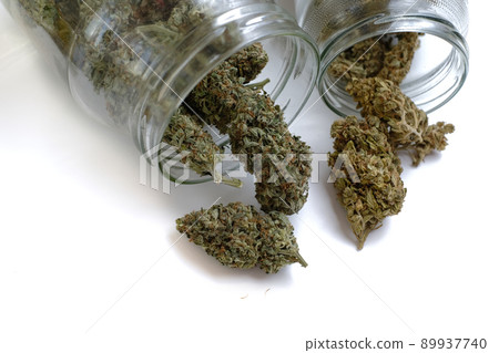 Dried medical cannabis buds in a jar on white background, isolated. 89937740