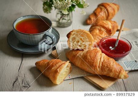 Closeup Table with Fresh baked croissant and tea 89937829