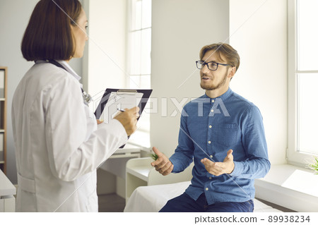 Young patient having conversation with physician during medical checkup at hospital Young patient having conversation with physician during medical checkup at hospital 89938234