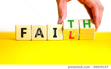 Faith instead fail symbol. Businessman turns wooden cubes and changes the concept word Fail to Faith. Beautiful yellow table white background. Business and faith instead fail concept. Copy space. 89939147