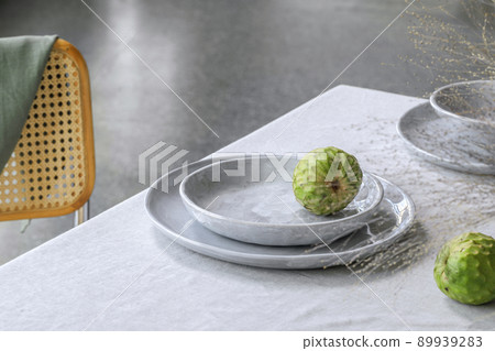 Elegant table setting with cherimoya fruits on linen tablecloth. Outdoor table setting for summer holiday concept. 89939283