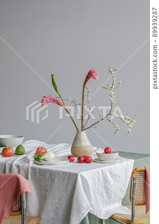Elegant table setting with cherry brunch in craft vase , cherimoya fruits, fenel and plums in craft ceramic plate on linen tablecloth. Outdoor table setting for summer holiday concept. 89939287