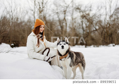woman in the snow playing with a dog fun friendship winter holidays woman in the snow playing with a dog fun friendship winter holidays 89939651