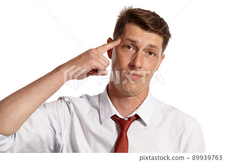 Young man in a classic white shirt and red tie posing isolated on white background. 89939763