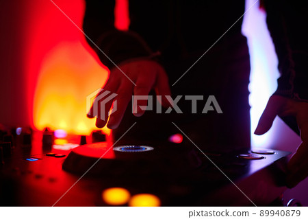 Hands of female Dj playing music on modern midi controller turntable. Digital device for mixing music on events and in studio. 89940879
