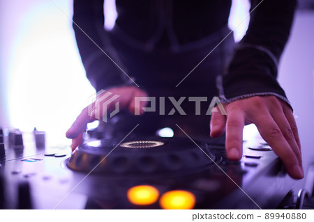 Hands of female Dj playing music on modern midi controller turntable. Digital device for mixing music on events and in studio. 89940880