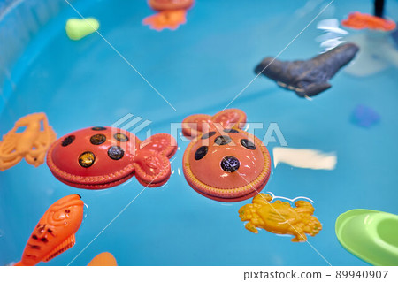 Multicolored plastic toy fish in pool for children's fishing, concept game. 89940907