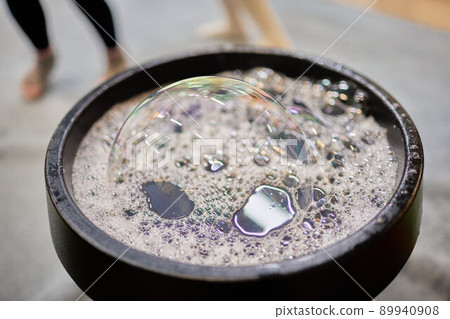 Close-up of child's hands with bowl and bubble blower. Selective focus. 89940908