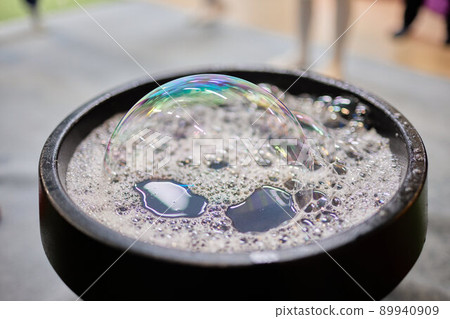 Close-up of child's hands with bowl and bubble blower. Selective focus. Close-up of child's hands with bowl and bubble blower. Selective focus. 89940909