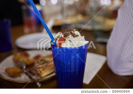 Chocolate indulgent frosting exreme milkshake with donut and sweets. Crazy freakshake food trend. Copy space. 89940994