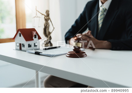 Law, Consultation, Agreement, Contract, Concept Attorney or lawyer focusing on the court hammer is sitting on the chair with a client's complaint to determine the house and land in court. 89940995