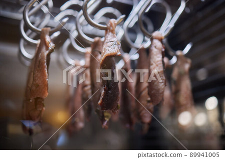 Close up of a smoked meat and belly or beech meat with dark crust in the smokehouse or smoker, food concept. Close up of a smoked meat and belly or beech meat with dark crust in the smokehouse or smoker, food concept. 89941005