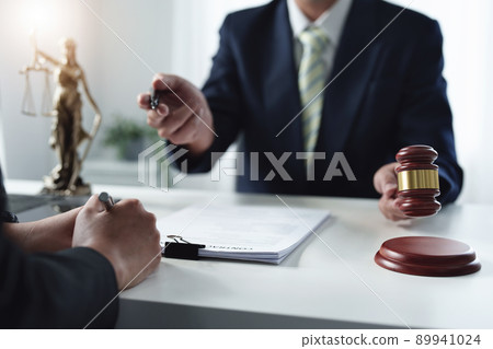 Focus at gavel, Attorney or Lawyer holding a pen is consulting with a client to explain the pattern of answering questions before going to court to decide a lawsuit Focus at gavel, Attorney or Lawyer holding a pen is consulting with a client to explain the pattern of answering questions before going to court to decide a lawsuit 89941024