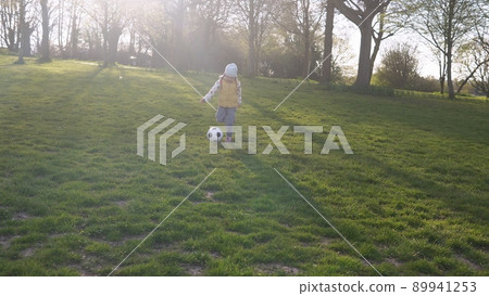 Happy Family Of Children Having Fun In Spring Park. Little Kid Run. Child Girl Dribbles Black White Classic Soccer Ball On Green Grass. People Playing Football. Childhood, Sport, Championship Concept 89941253