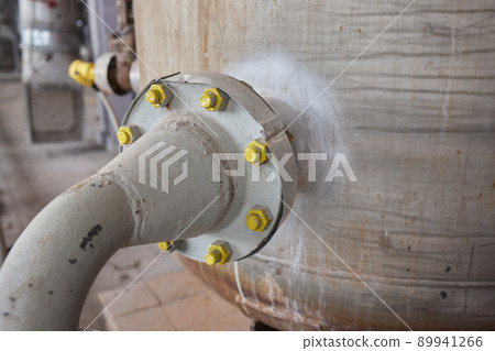 Close-up at pipeline valve which is using to control production process in the oil refinery plant. Selective focus at the valve handle wheel, Heavy industrial object photo. Close-up at pipeline valve which is using to control production process in the oil refinery plant. Selective focus at the valve handle wheel, Heavy industrial object photo. 89941266