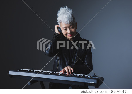 Gray-haired woman playing the keyboard 89941473