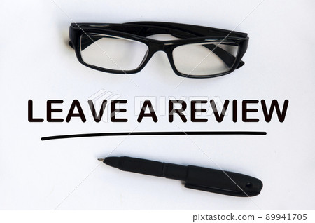 Leave a review text on white cover with pen and glasses background. Feedback and review concept. 89941705