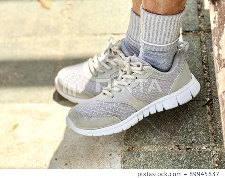 The feet of the athletic shoes that I sat down and piled up 89945837