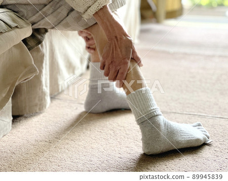 Elderly woman's hand stretching the calf of the foot Elderly woman's hand stretching the calf of the foot 89945839