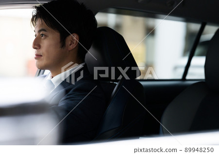 Male businessman driving a car Male businessman driving a car 89948250