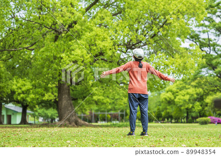 A young woman taking a deep breath at the park A young woman taking a deep breath at the park 89948354