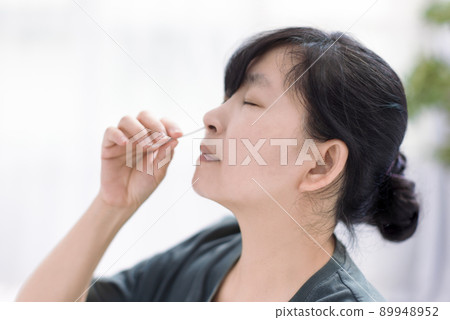 Woman using covid-19 rapid antigen test kit home 89948952