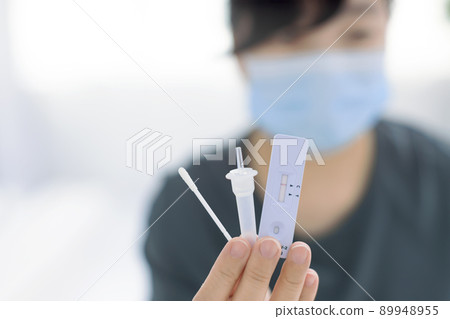 Woman using covid-19 rapid antigen test kit home 89948955