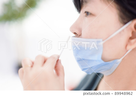 Woman using covid-19 rapid antigen test kit home 89948962