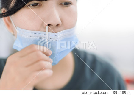 Woman using covid-19 rapid antigen test kit home 89948964