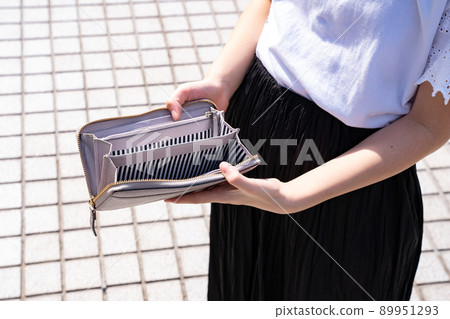 Woman opening an empty wallet Woman opening an empty wallet 89951293