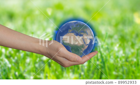 A woman's hand holding model of the planet on green background, earth day concept. Save the green world A woman's hand holding model of the planet on green background, earth day concept. Save the green world 89952933