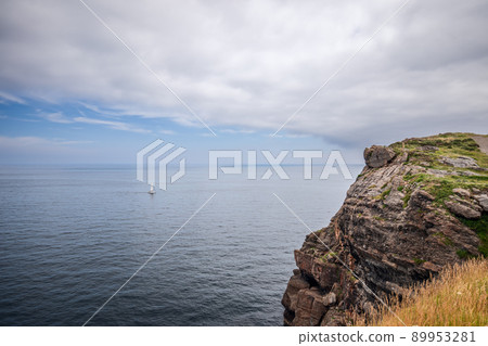 Spanish coast of Bay of Biscay, calm waters of Cantabrian Sea with lonely white sailing yacht Spanish coast of Bay of Biscay, calm waters of Cantabrian Sea with lonely white sailing yacht 89953281