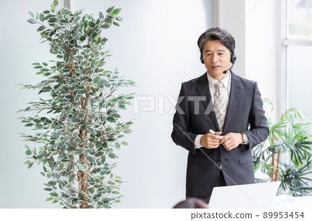 A business person who wears a headset and talks in public 89953454